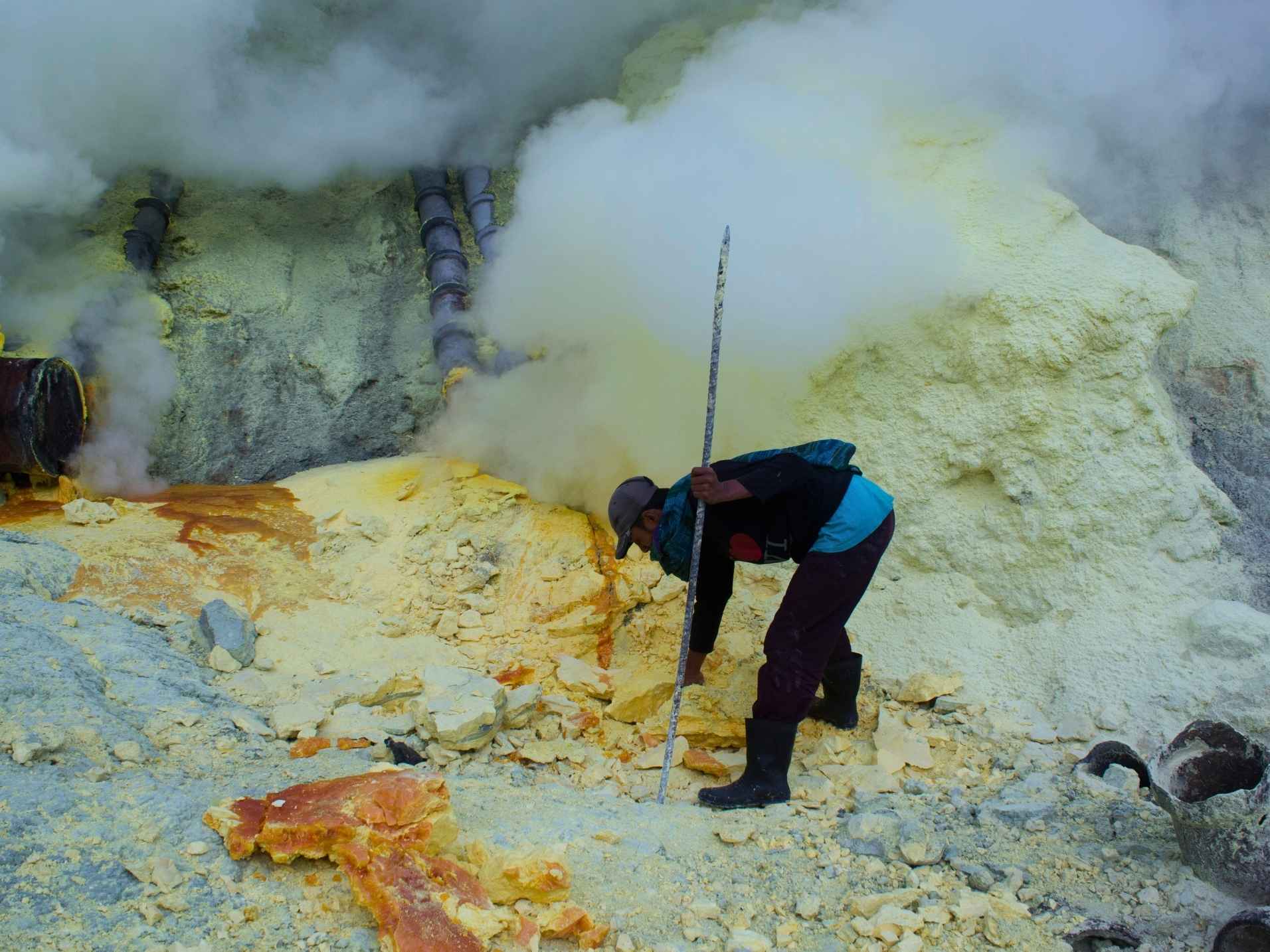Traditional sulfur miners inside Ijen Crater carrying sulfur blocks