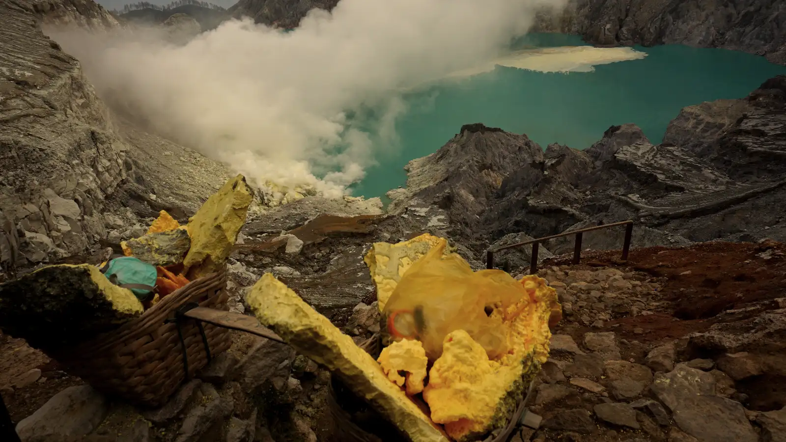 Travelers hiking on the rim of Ijen Crater during sunrise