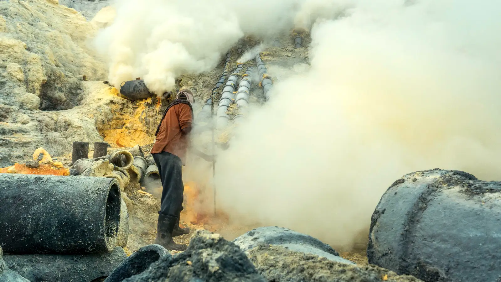 Close up of sulfur miners carrying baskets near the crater rim