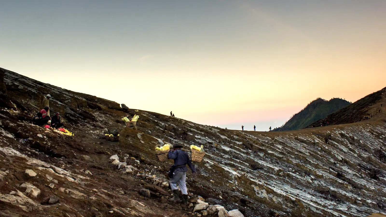 The steep hiking trail of Mount Ijen with sulfur smoke in the distance