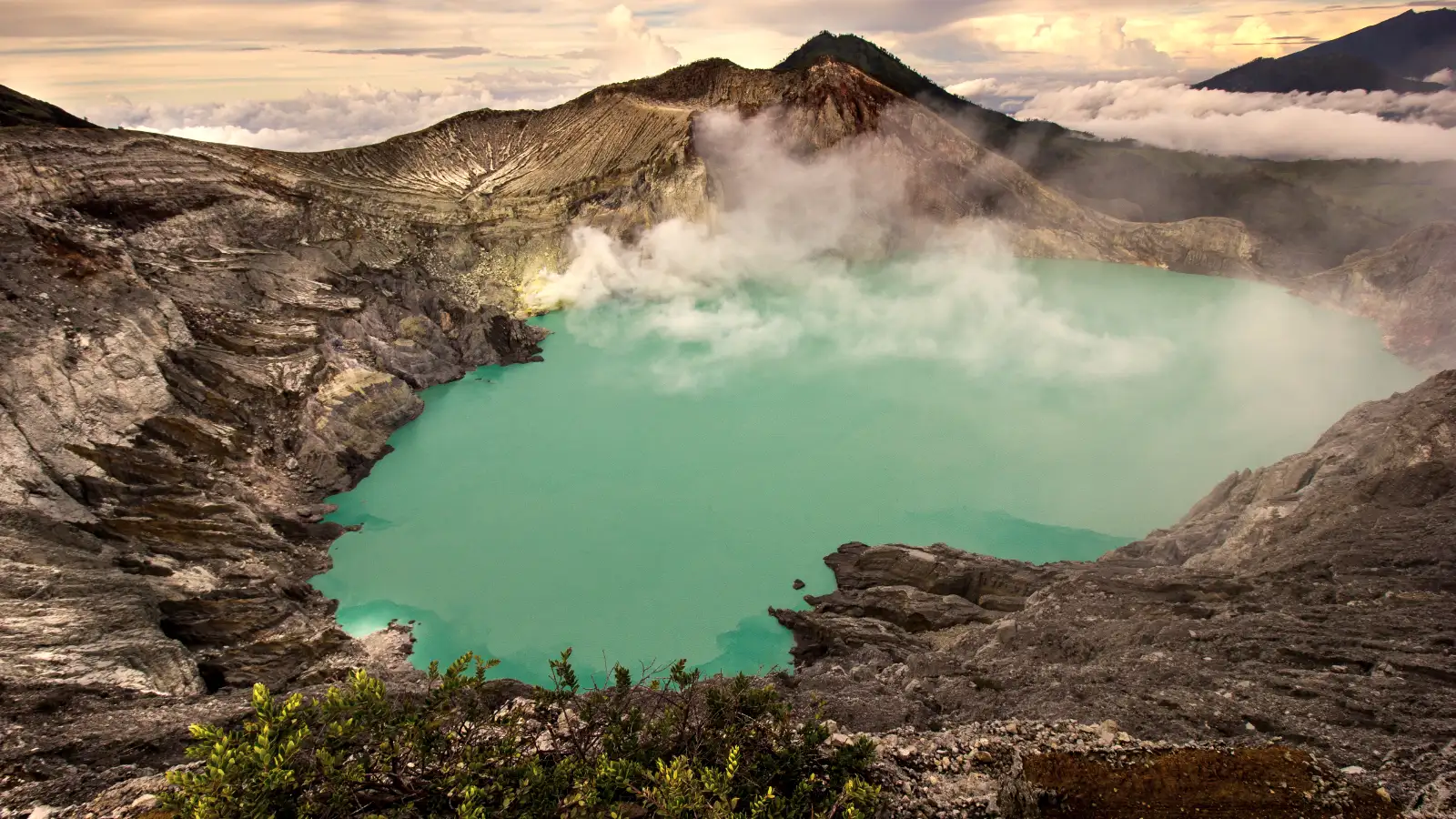 Proper Safety Gear for Kawah Ijen Trekking Travelers wearing gas masks while hiking near the Ijen sulfur smoke