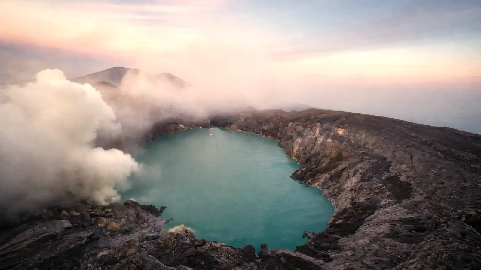 The Breathtaking Active Crater of Mount Ijen at Dawn Sunrise over the active Mount Ijen crater showing the turquoise acid lake and volcanic steam