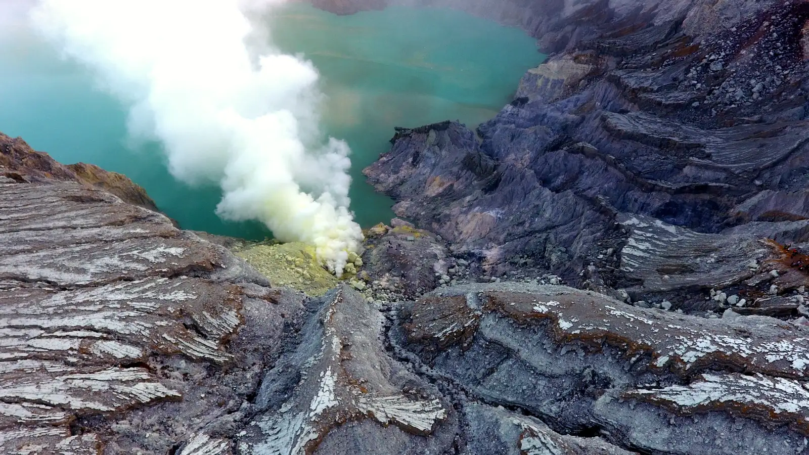The turquoise acidic lake of Ijen Crater surrounded by volcanic walls