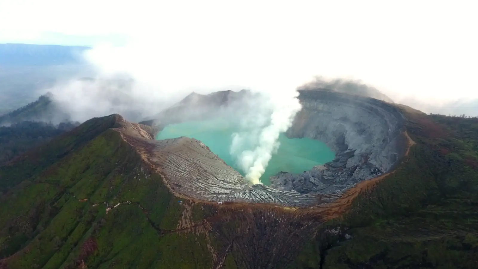 Detailed view of the acidic lake surface at Kawah Ijen with yellow sulfur deposits