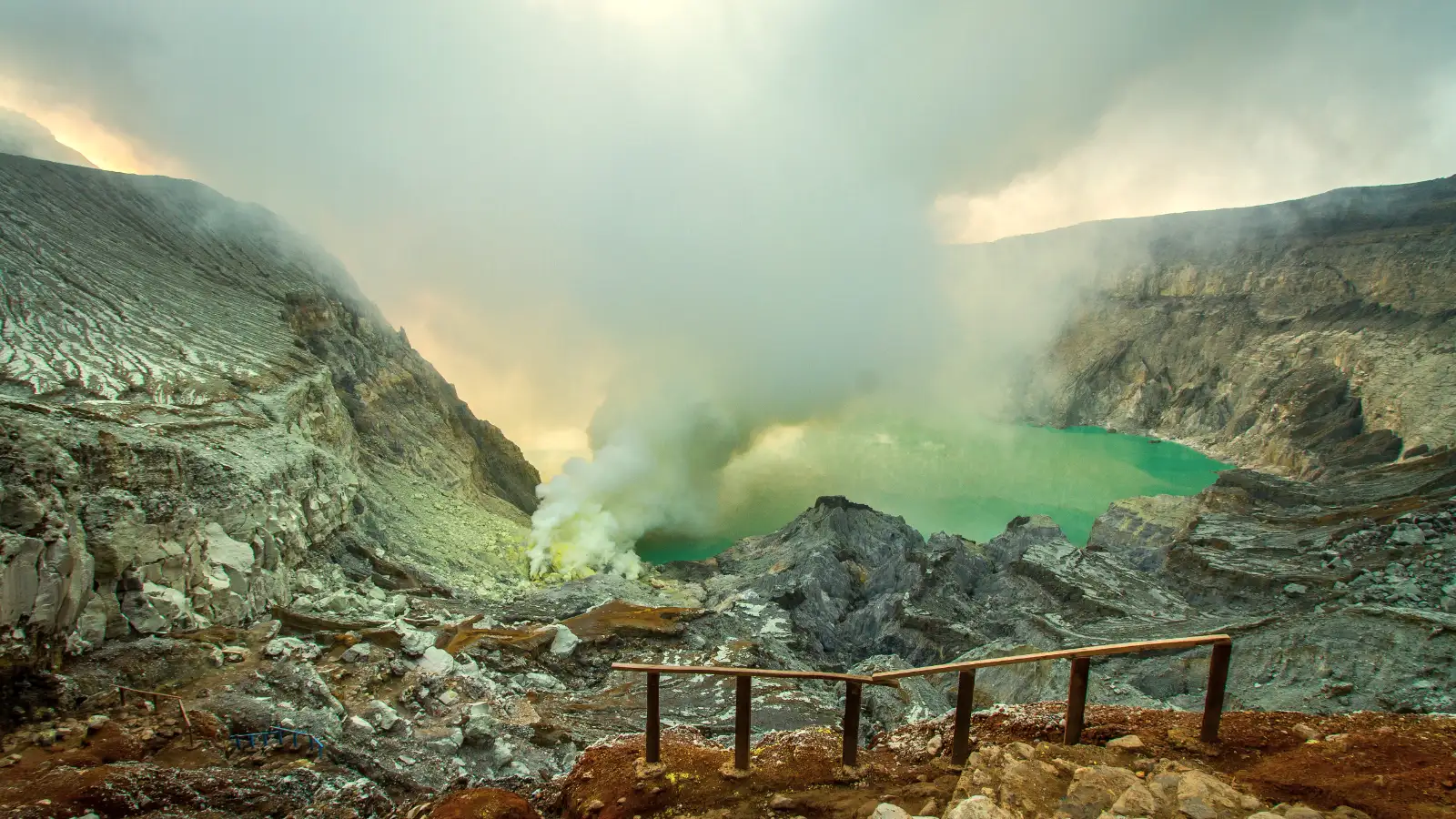 The Harsh Terrain of Ijen Crater Hiking trail and sulfur mining area at Kawah Ijen with gas clouds