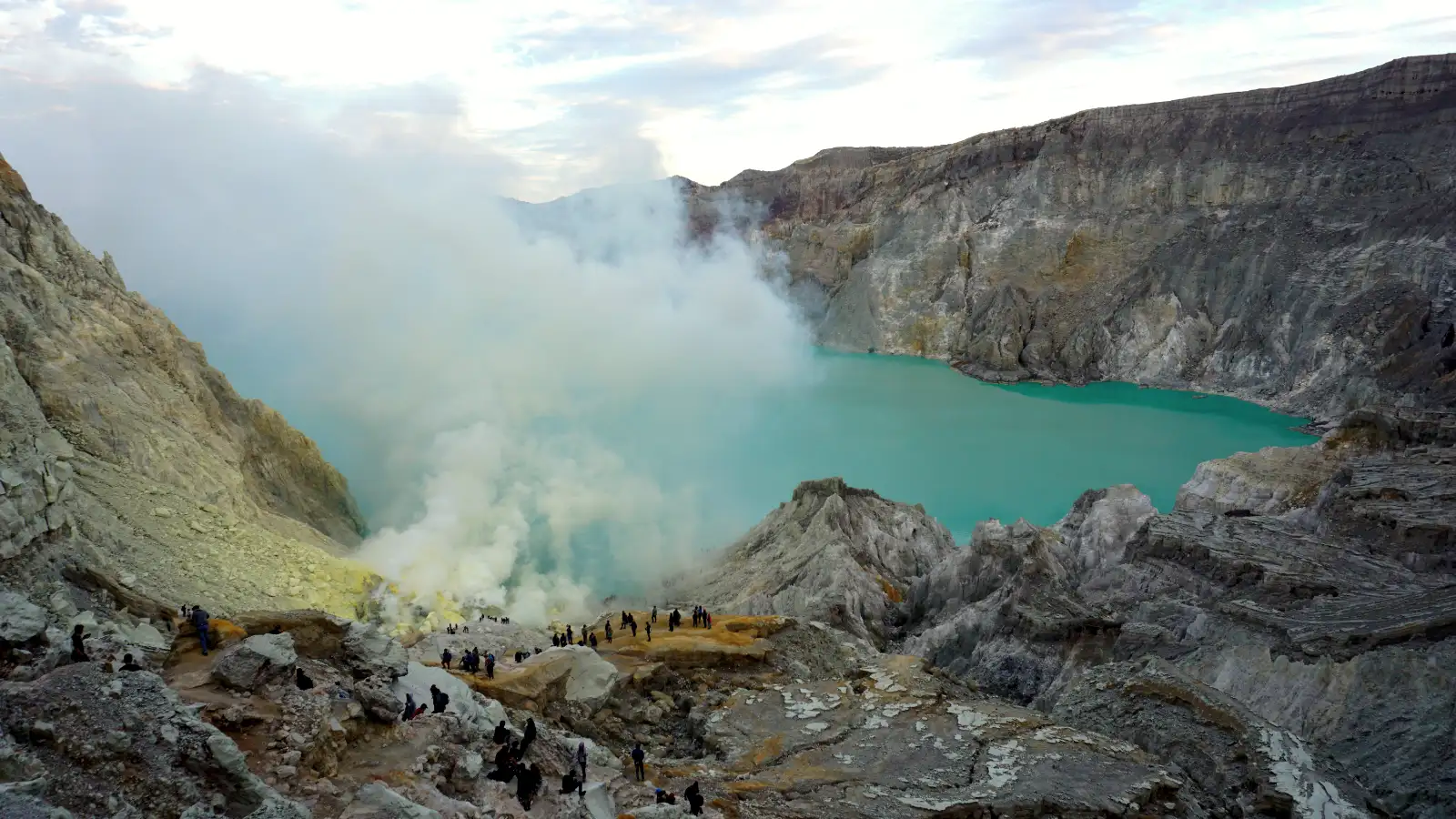 Stunning morning view of the Kawah Ijen acidic lake Vibrant turquoise acidic lake at Kawah Ijen crater during a sunrise tour from Bali