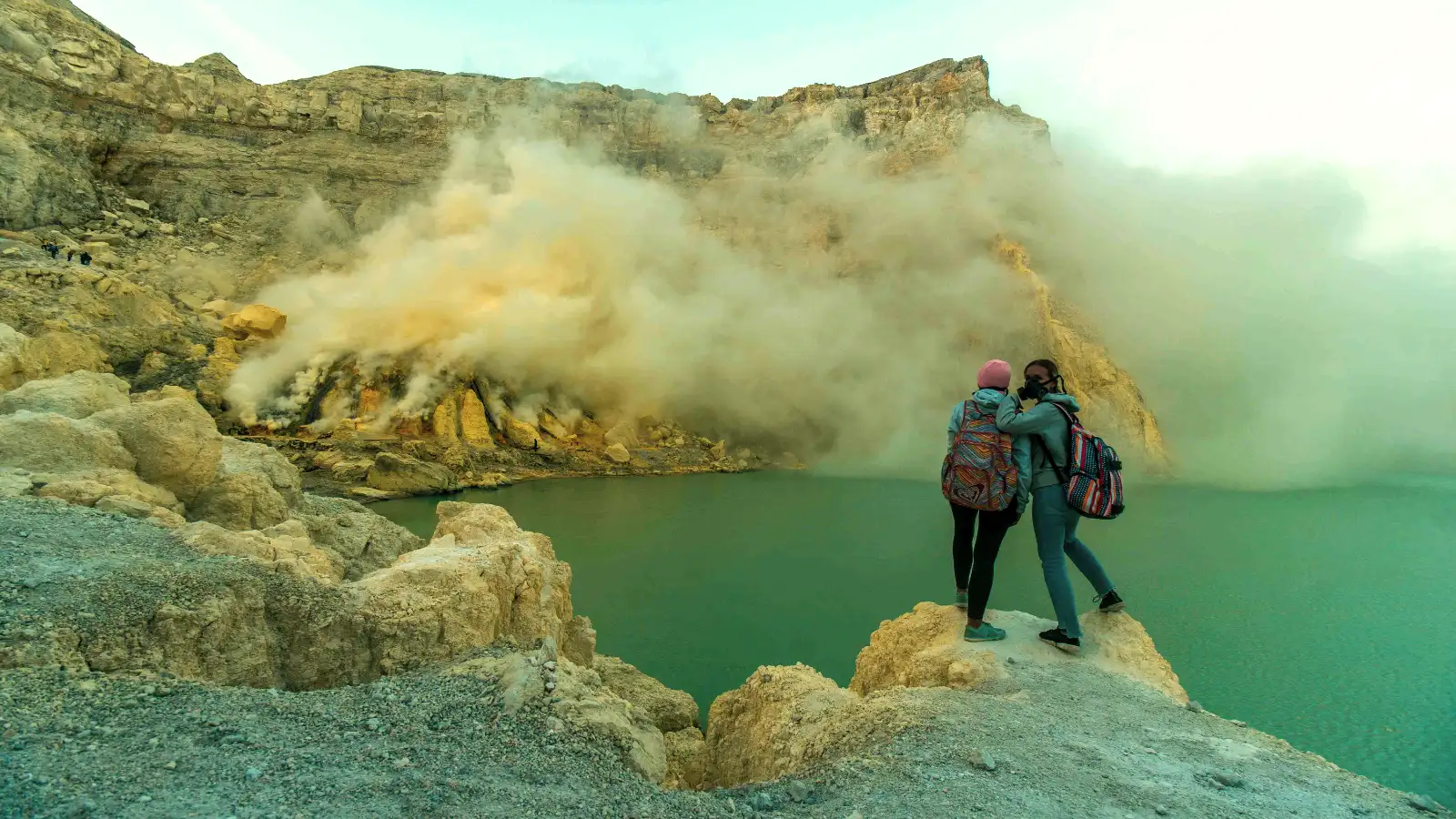 The Stunning Acid Lake of Mount Ijen at Dawn Vibrant turquoise acid lake and sulfur gas at the Ijen Crater summit during a Java volcanic expedition