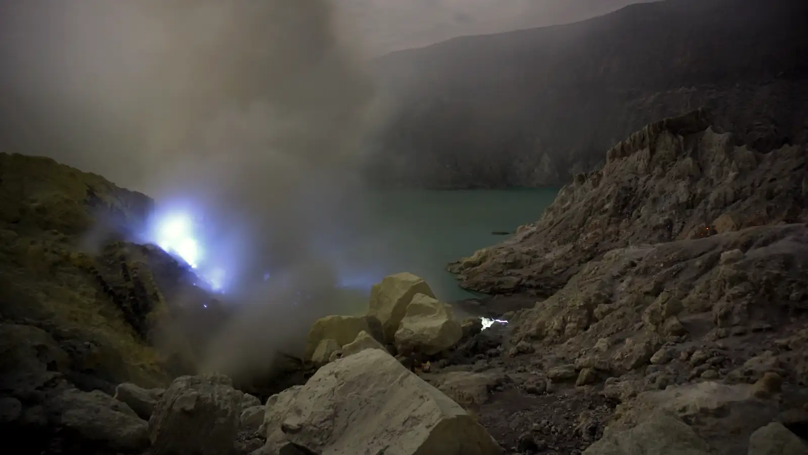 Local sulfur miners navigating the steep slopes of Mount Ijen