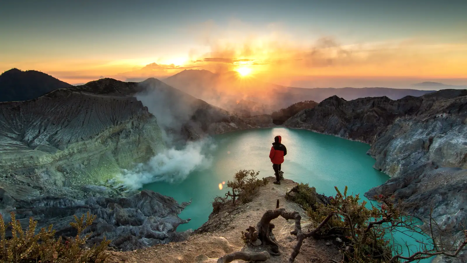 Vibrant turquoise acidic lake inside the Mount Ijen crater at sunrise