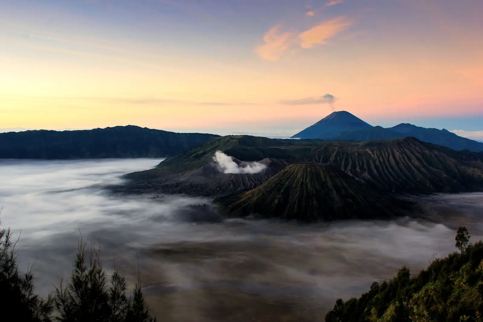 Scenic sunrise view of Mount Bromo caldera with clouds and morning light