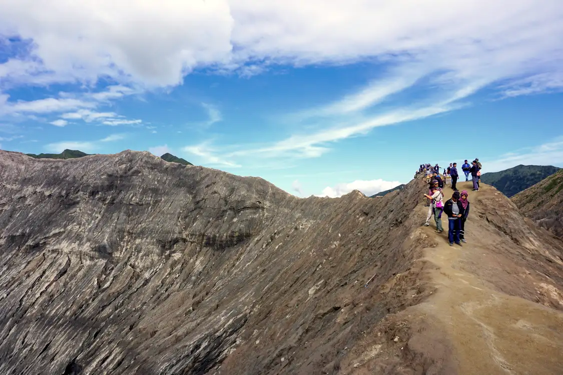 Trekking the Sea of Sand Travelers hiking across the volcanic sand plain toward the base of Mount Bromo